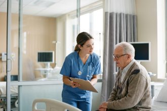 Infirmière soignante expliquant un médicament à un patient âgé