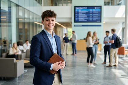 Jeune étudiant confiant dans un hall moderne d'école de commerce
